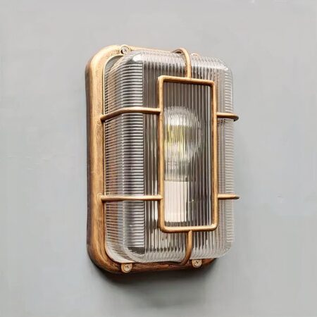 su una parete grigio chiaro, un'applique vintage con oblò in stile industriale per interni ed esterni