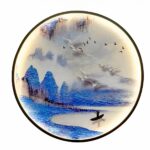 una lampada da parete rotonda con un paesaggio giapponese è mostrata su uno sfondo bianco