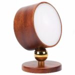 Lampada da lettura a parete con base in legno, sfera magnetica dorata e testa luminosa rotonda, contorno color legno. Sfondo bianco.